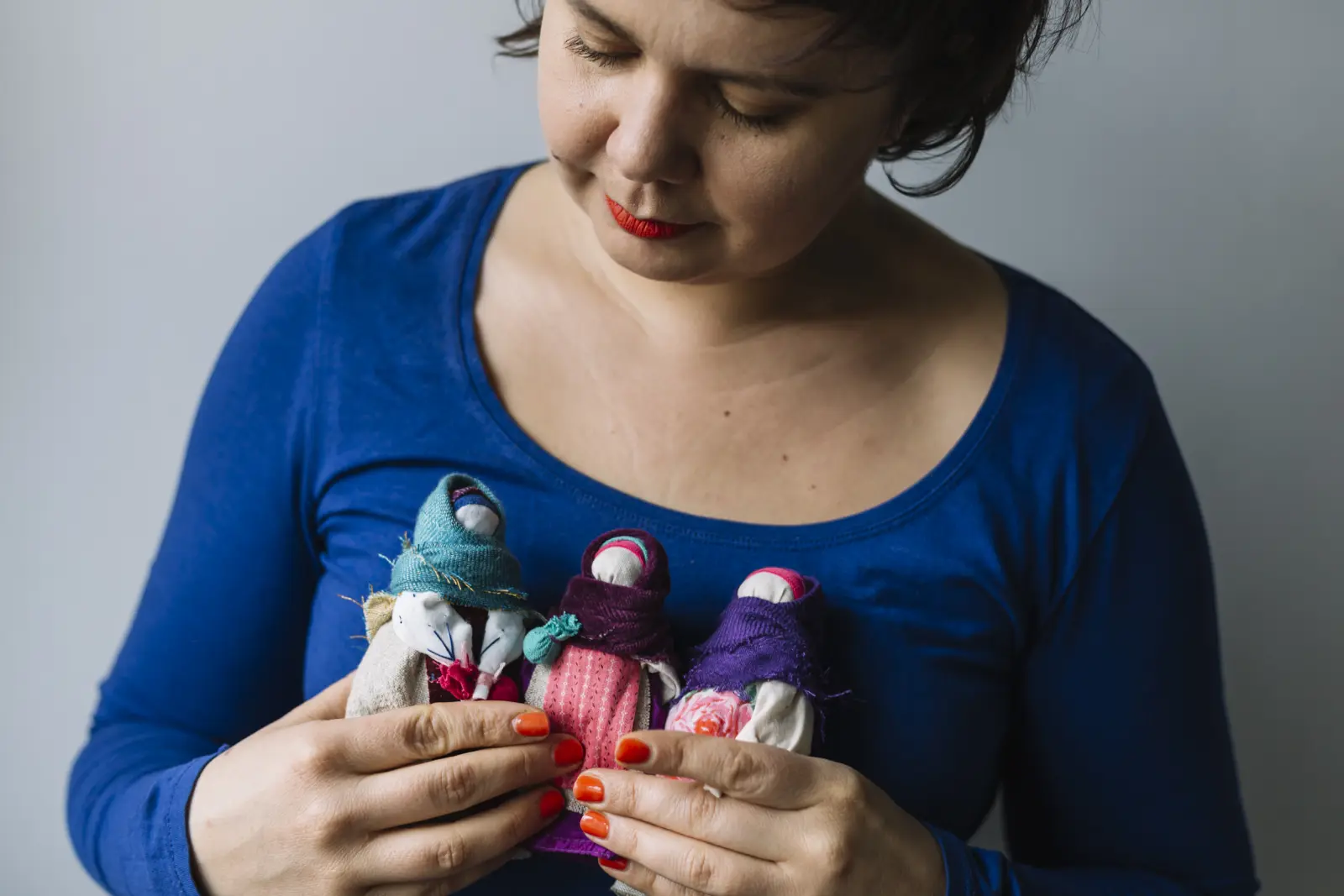 Kasia Dorota trzyma w ręki trzy Podróżki, motanki