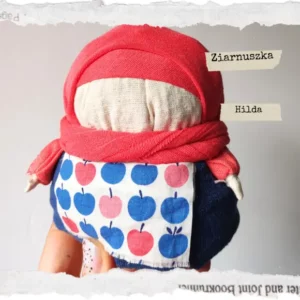 Tradycyjna Motanka, wykonana z tkaniny i wypełniona ziarnami. Ma pękaty kształt i kolorowe ubranie - chustkę na głowie, sukienkę i fartuszek. Jest jedną z największych motanek.