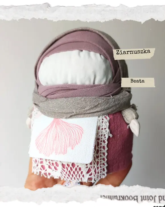 Tradycyjna Motanka, wykonana z tkaniny i wypełniona ziarnami. Ma pękaty kształt i kolorowe ubranie - chustkę na głowie, sukienkę i fartuszek. Jest jedną z największych motanek.