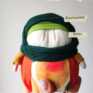 Tradycyjna Motanka, wykonana z tkaniny i wypełniona ziarnami. Ma pękaty kształt i kolorowe ubranie - chustkę na głowie, sukienkę i fartuszek. Jest jedną z największych motanek.