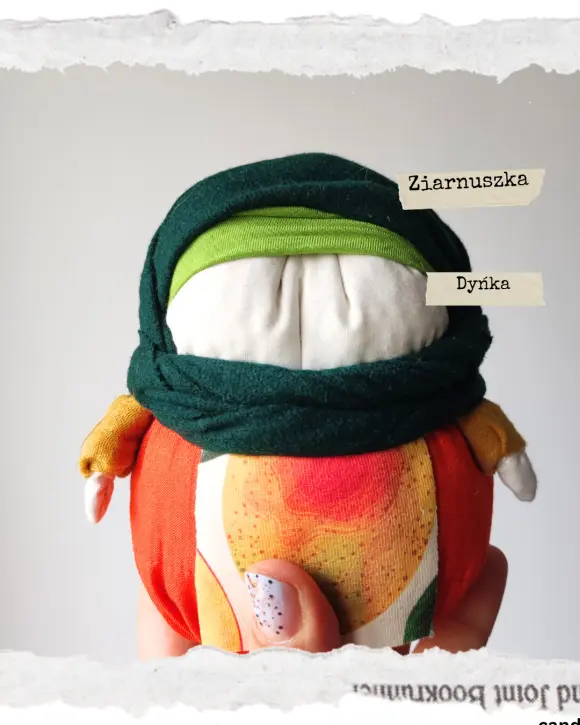 Tradycyjna Motanka, wykonana z tkaniny i wypełniona ziarnami. Ma pękaty kształt i kolorowe ubranie - chustkę na głowie, sukienkę i fartuszek. Jest jedną z największych motanek.