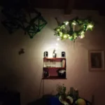 wiszący nad stołem podłaźnik z gałęzi sosny ozdobiony lampeczkami