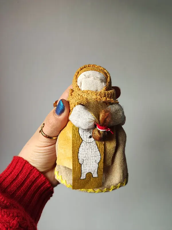Podóżka, Lalka Mocy, zamotana z żółtych tkanin z białym niedźwiedziem na fartuszku