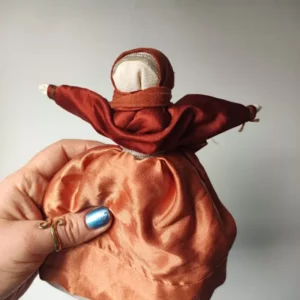 Lalka Motanka wykonana z tkanin i nici w kolorze miedzianym