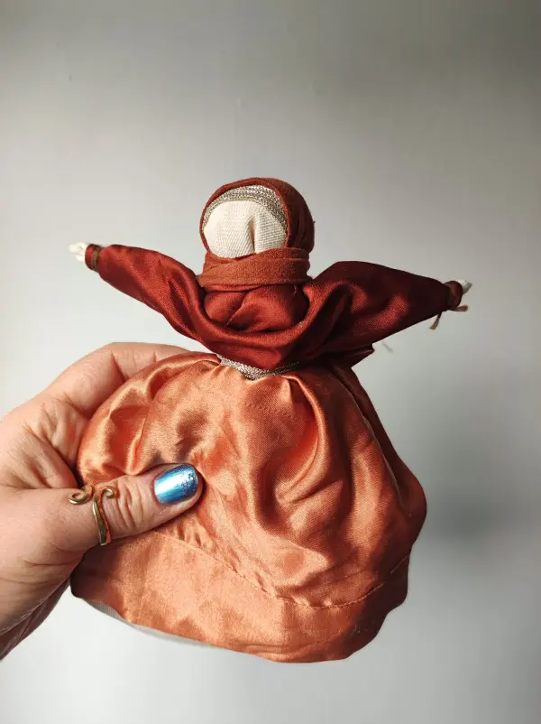 Lalka Motanka wykonana z tkanin i nici w kolorze miedzianym