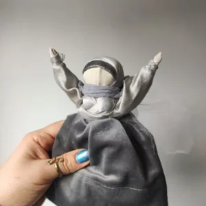 Lalka zamotana z tkanin i nici w kolorze srebrnym.