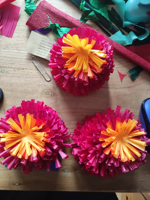 Kalinki ozdoby wykonane z bibuły. koloru czerwonego, z pomarańczowym i żółtym akcentem.